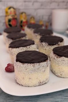 several desserts on a white plate with raspberries