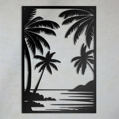 a metal wall art depicting palm trees and the ocean