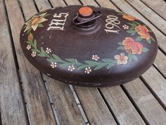 a wooden bench with a painted pot on it's side and the words that spell out