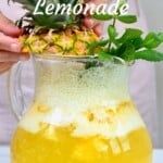 a person is holding a pineapple in a glass pitcher filled with lemonade and mint