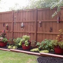 an outdoor landscape with potted plants and wooden fence in the back yard, on instagram