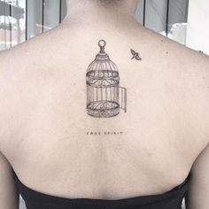 a woman with a bird cage tattoo on her back