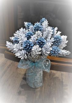 a vase filled with blue and white snowflakes on top of a wooden table