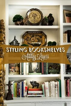 a white book shelf filled with books next to a clock and other decorative items on top of it