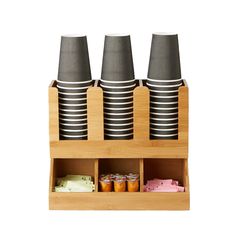 three cups are stacked on top of each other in a holder with compartments for cupcakes