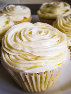 cupcakes with white frosting sitting on a plate