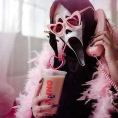 a woman wearing a mask and holding a drink