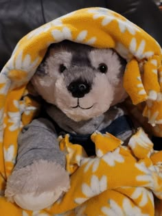 a stuffed animal is wrapped in a blanket