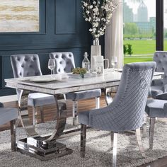 a dining room table with grey chairs around it