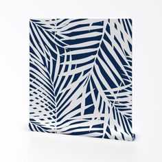 a blue and white palm leaf pattern on a square tile wall hanging in front of a white background