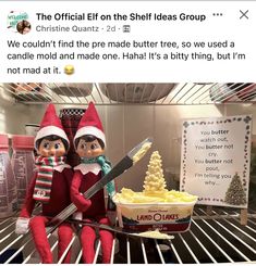 two elfs sitting on top of a refrigerator next to a bowl of butter and a knife