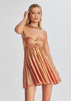 Enhance your soiree style with our Kaiser Dress. This strapless mini piece features a pleated bodice, coordinating skirt, and a bright metallic finish. Shown here in Apricot. 95% Polyester, 5% Spandex Made in China Model size XS is 5'10" wearing size XS Model size L is 5'11" wearing size L Style No. FW22-5608 Strapless Mini Dress With Pleated Bodice For Party, Strapless Party Mini Dress With Pleated Bodice, Ruched Strapless Mini Dress For Party Season, Gala Mini Strapless Dress With Ruched Bodice, Strapless Pleated Mini Dress For Evening, Strapless Pleated Evening Mini Dress, Strapless Cocktail Mini Dress With Ruched Bodice, Flirty Pleated Mini Dress For Party, Strapless Mini Dress With Ruched Bodice For Cocktail