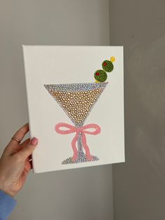 a hand holding up a card with an image of a martini