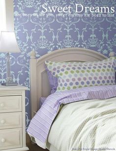 a bedroom with purple walls and white furniture