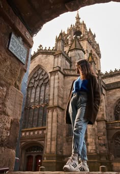 a woman standing on steps in front of an old building