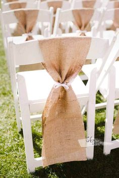 white chairs with burlap sashes and bows tied to the back of them