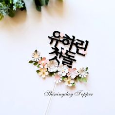 a cake topper with flowers on it and the words happy birthday written in korean