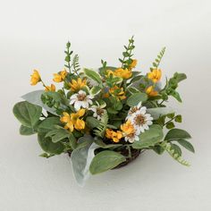 a basket filled with yellow and white flowers