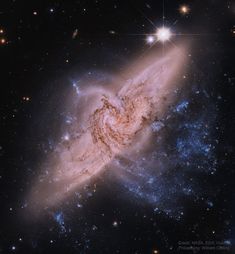 an image of a spiral galaxy in the sky with stars on it's sides