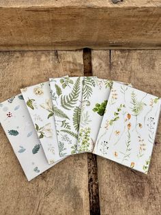 four napkins with different designs on them sitting next to each other in front of a wooden surface