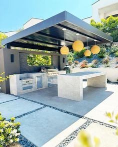 an outdoor kitchen and dining area in a backyard