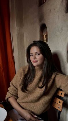 a woman sitting in a chair next to a window