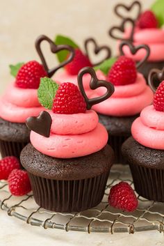 chocolate cupcakes with raspberry frosting and chocolate hearts on the top