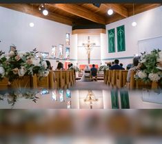 people are sitting at the alters in a church with flowers on the pews