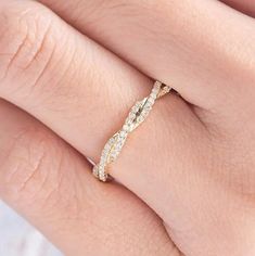 a woman's hand with a diamond ring on her wedding day, wearing a yellow gold band