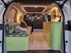 the interior of a van with its doors open and furniture in place to seat people