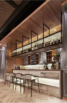 an empty bar with several stools in front of it and shelves on the wall