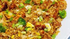 a white plate topped with fried rice and broccoli