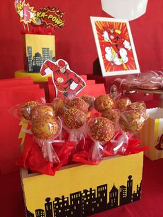 a box filled with chocolate covered donuts sitting on top of a red table cloth