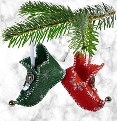 two christmas ornaments hanging from a tree branch