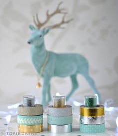 several different types of tape are sitting on a table next to a deer figurine