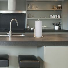 a kitchen counter with two stools next to it and an oven in the background