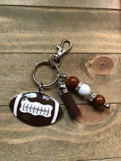 a football keychain with a ball and tassel hanging from it's side