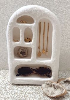 a white display case with sunglasses and other accessories