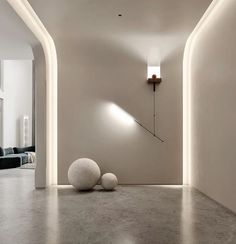 an empty room with two white balls on the floor and a light fixture in the corner