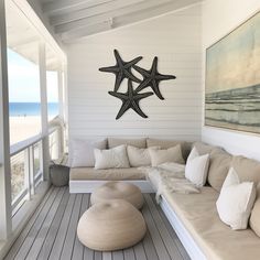 a living room filled with lots of furniture next to an ocean side wall mounted starfish