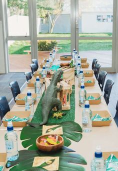 a table set up with water bottles, plates and napkins for an animal themed party