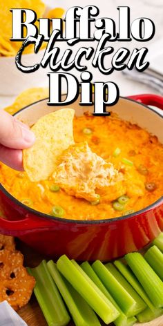 buffalo chicken dip in a red pot with celery and crackers