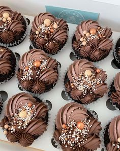 chocolate cupcakes with frosting and sprinkles arranged in a box