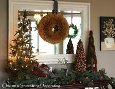 christmas decorations and wreaths are displayed on the mantle in front of a window with an evergreen wreath