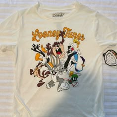 Looney Tunes Tee Shirt Sz Xs Nwt White. Measurements Approximate While Lying Flat 16.5” Armpit To Armpit 6” Sleeves 24.5” Long Loony Tunes Shirt, White Graphic Tee With Cartoon Print, White Cartoon Print Graphic Tee, Retro White Shirt With Character Print, White Retro Tops With Character Print, White Graphic Print Fun Top, Hufflepuff Shirt, Slytherin Shirt, Harry Potter Graphic Tees