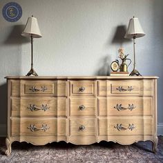 an old dresser with two lamps on top