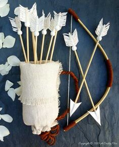 an arrangement of white flowers and arrows on a blue background