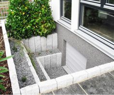 an outdoor area with concrete blocks and plants in the corner, next to a window