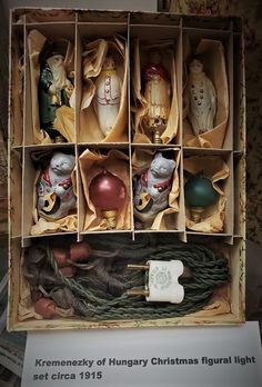 an open box with twelve christmas ornaments in it