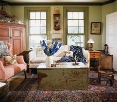 a living room filled with lots of furniture and decor on top of carpeted flooring